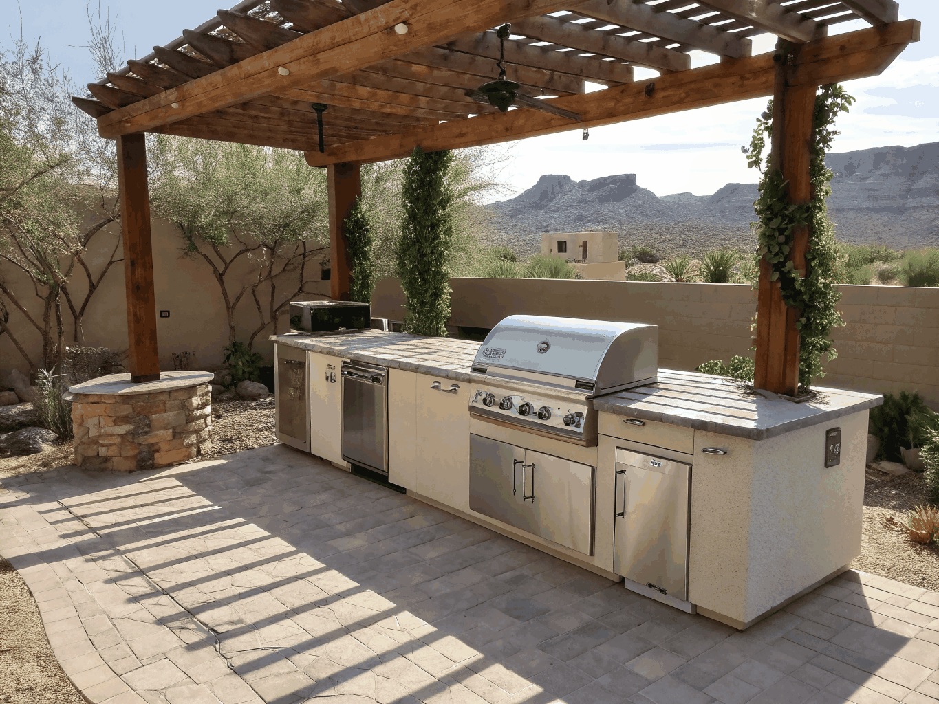 Modern luxury landscape design featuring a stone patio, outdoor kitchen, and custom pergola in a Colorado backyard